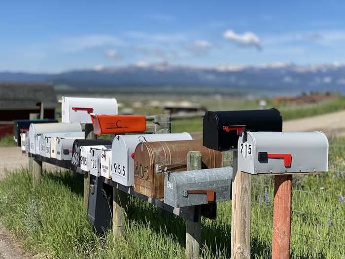 A row of residential mailboxes along a rural fence line